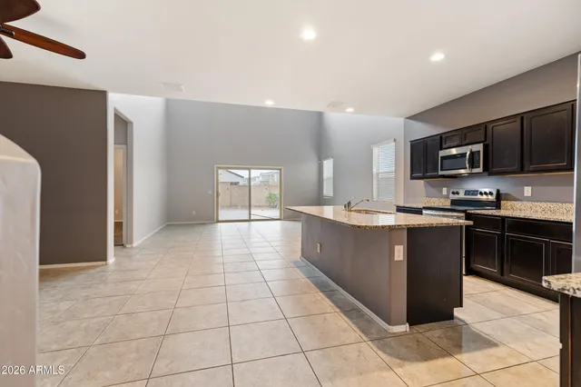 a view of kitchen with kitchen island granite countertop a stove top oven and cabinets