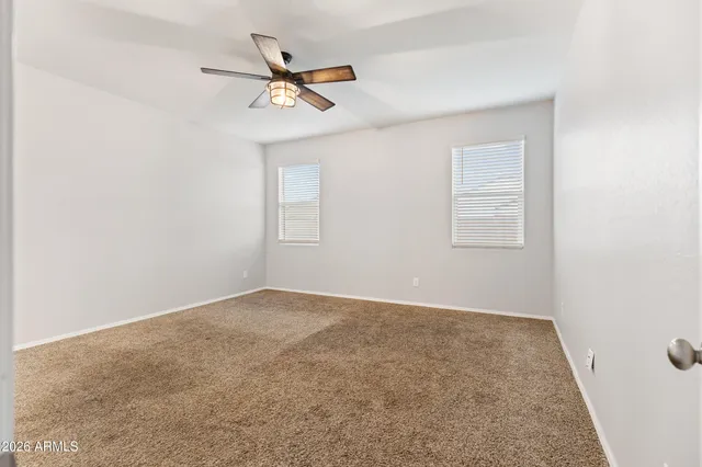 a view of an empty room with a ceiling fan