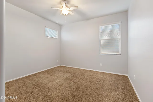 an empty room with a ceiling fan and a window