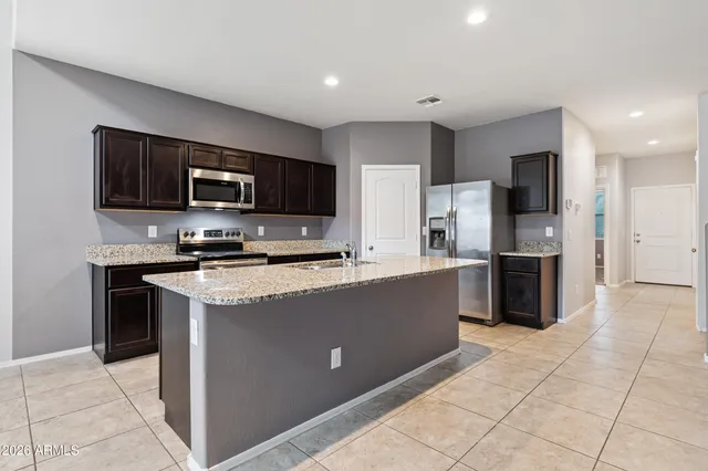 a kitchen with stainless steel appliances granite countertop a refrigerator and a stove top oven