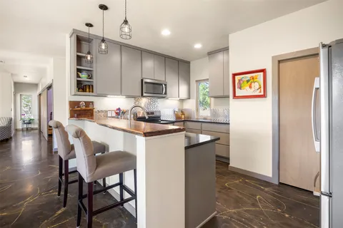 a kitchen with granite countertop a sink appliances and cabinets