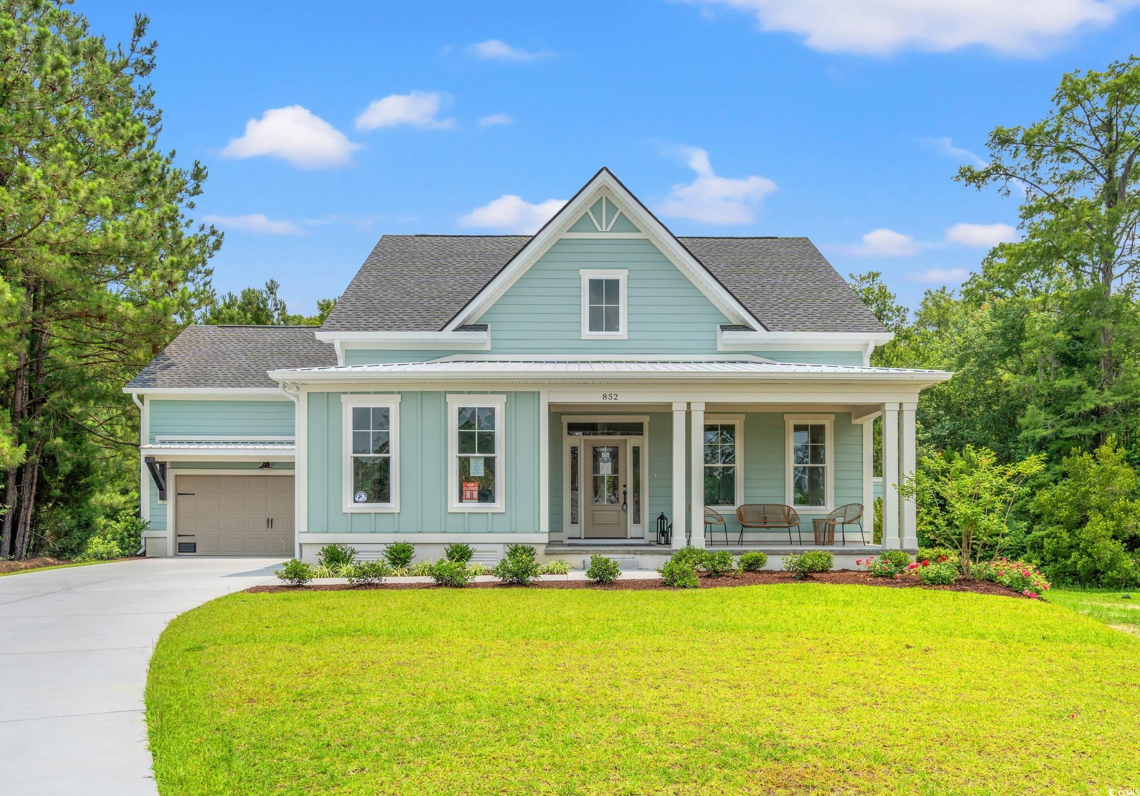 852 Commanders Island Road Georgetown, SC 29440 - Photo 1 of 37 View of front of house featuring covered porch, a shingled roof, board and batten siding, a front yard, and driveway