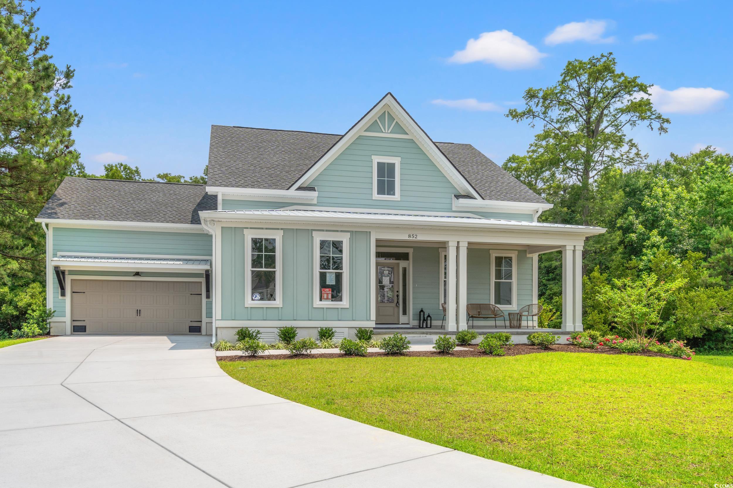 852 Commanders Island Road Georgetown, SC 29440 - Photo 2 of 37 View of front of property with a porch, board and batten siding, a front yard, concrete driveway, and an attached garage