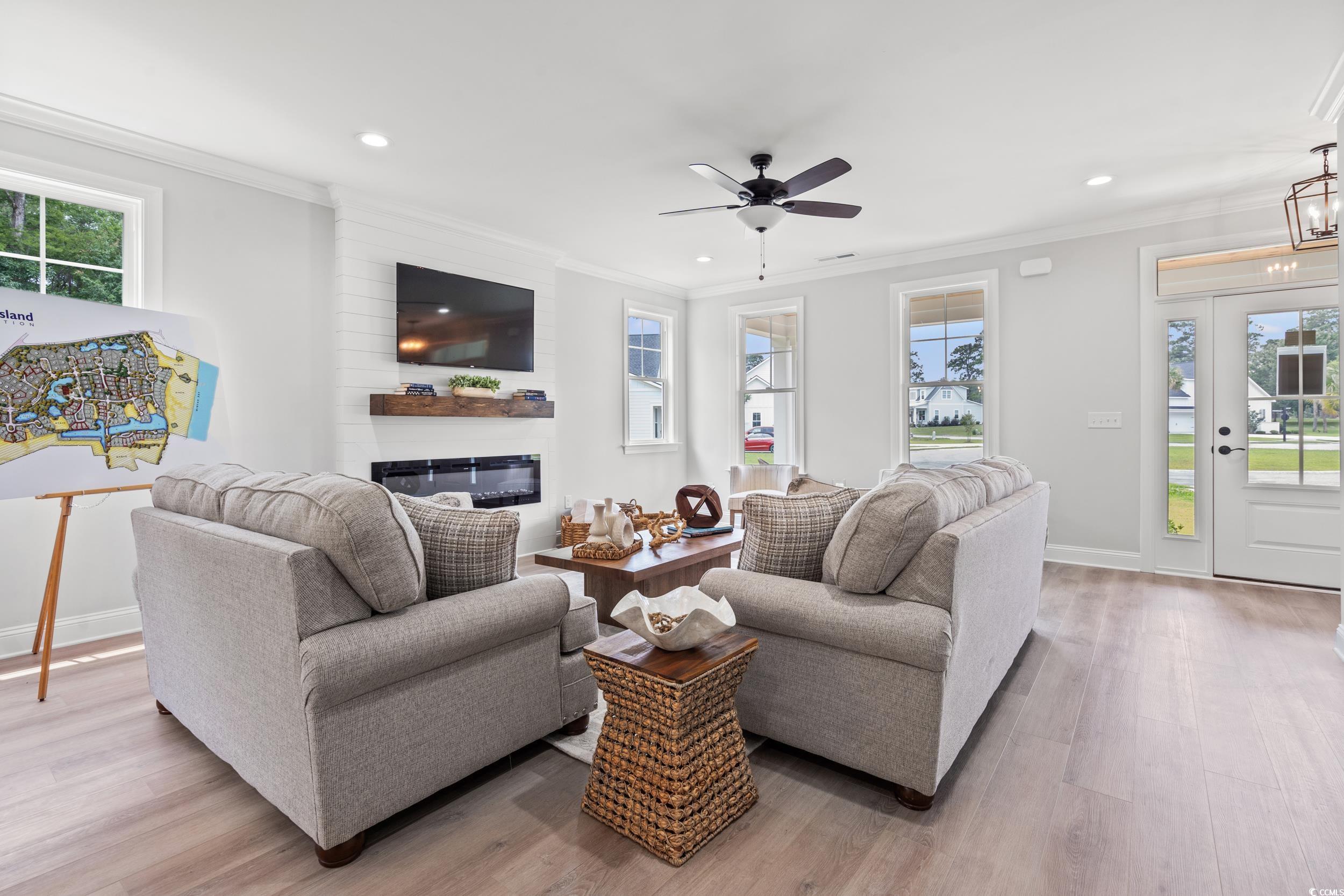 852 Commanders Island Road Georgetown, SC 29440 - Photo 4 of 37 Living room with ornamental molding, recessed lighting, a glass covered fireplace, light wood-style floors, and a ceiling fan