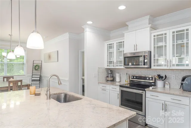 a kitchen with stainless steel appliances granite countertop a sink a stove and a refrigerator