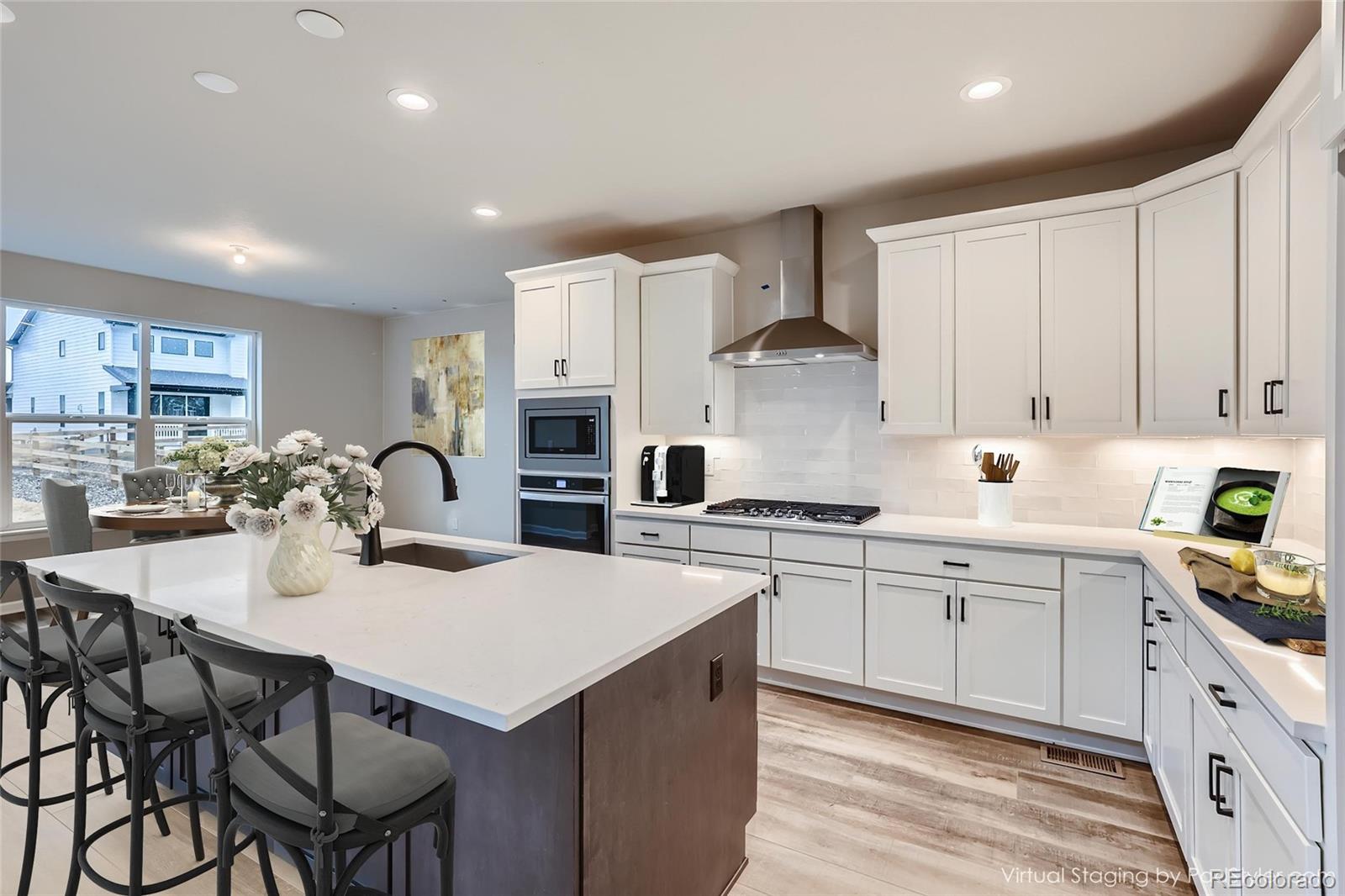 624 Simmental Loop Castle Rock, CO 80104 - Photo 4 of 9 a kitchen with stainless steel appliances a table chairs sink refrigerator and cabinets