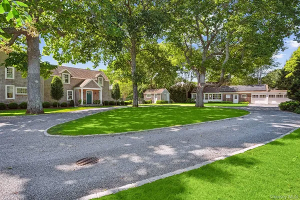 a front view of a house with a garden and trees
