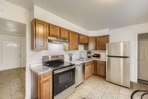 a kitchen with stainless steel appliances granite countertop a stove a refrigerator and a sink