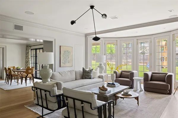 a living room with furniture dining table and a large window