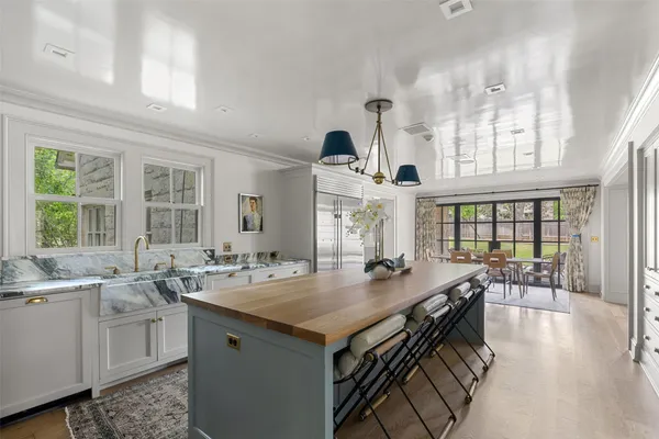 a kitchen with a stove a sink dishwasher and a dining table with wooden floor