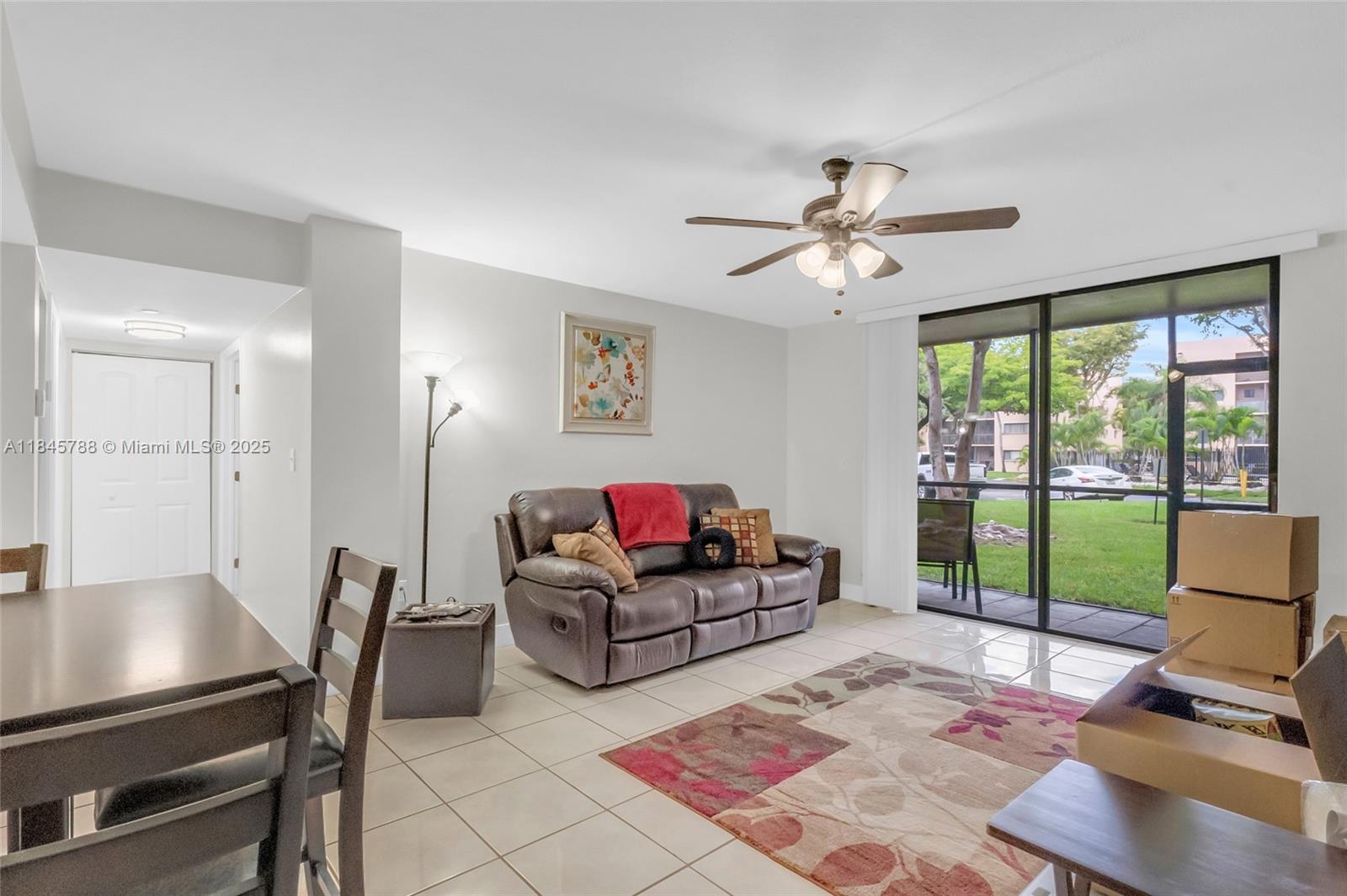 8760 Southwest 133rd Avenue Road, Unit 108 Miami, FL 33183 - Photo 24 of 39 a living room with furniture and a floor to ceiling window
