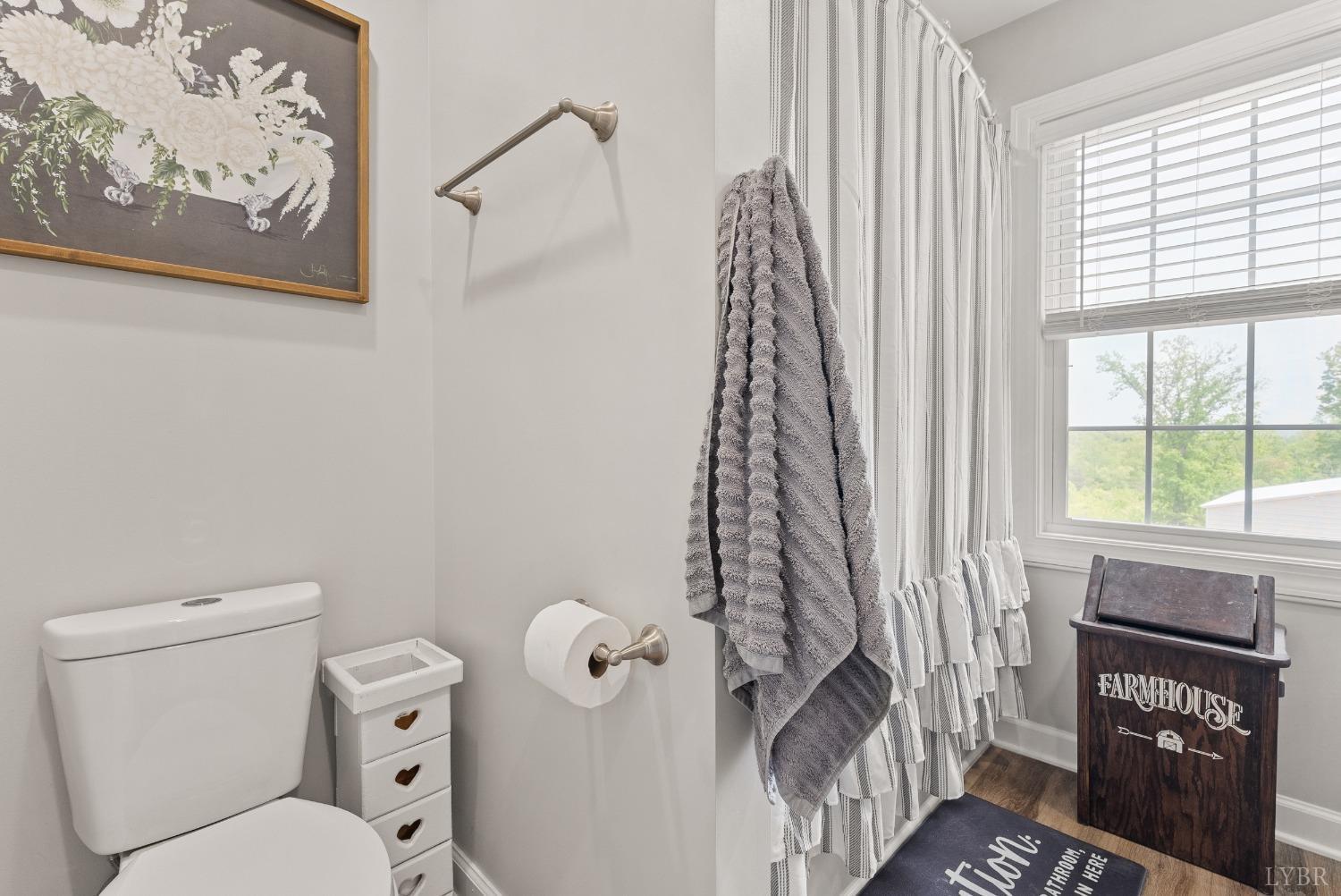 4607 Lowry Road Goode, VA 24556 - Photo 28 of 64 a bathroom with a toilet and a shower curtain