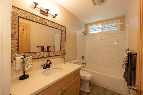 a bathroom with a sink a toilet and shower