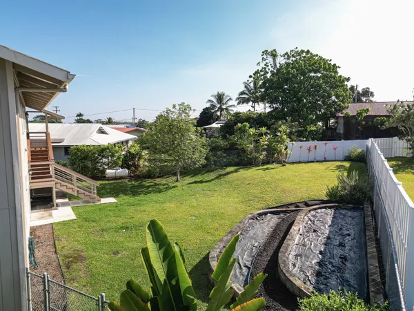 a view of a swimming pool with a patio and a yard