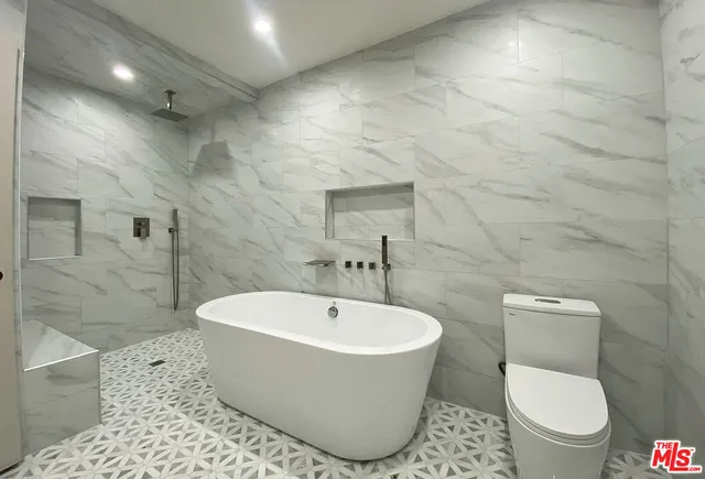 a white toilet sitting next to a bathroom sink and a shower