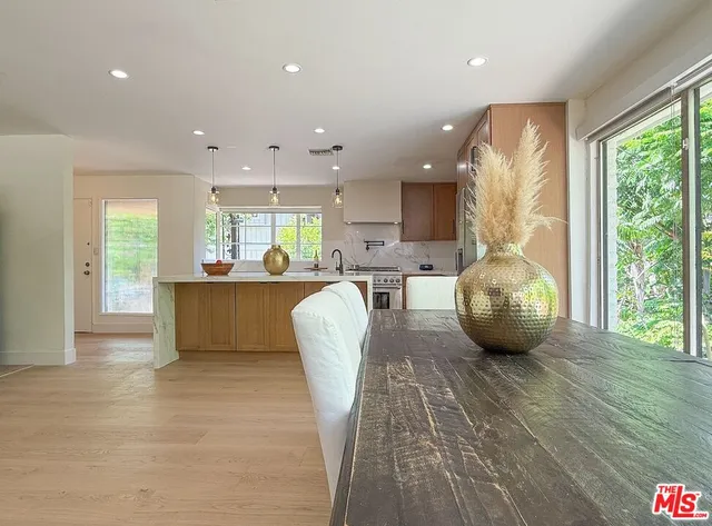 a view of a kitchen with kitchen island granite countertop a large window cabinets and stainless steel appliances