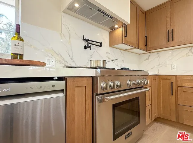 a stove top oven sitting inside of a kitchen