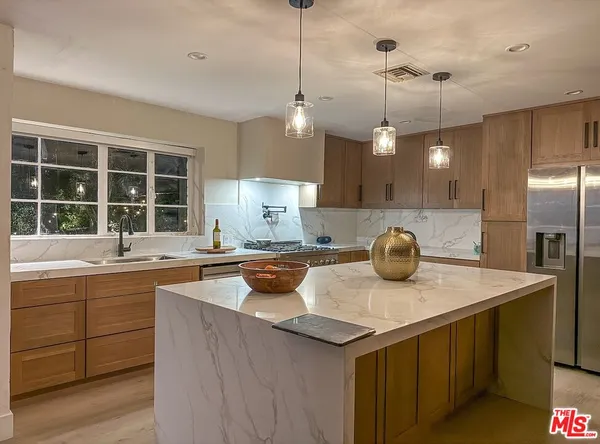 a kitchen with a sink a counter space appliances and cabinets