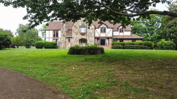 a front view of a house with a garden and yard
