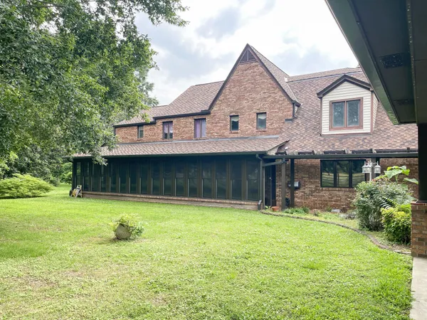 a view of a house with a yard and a tree