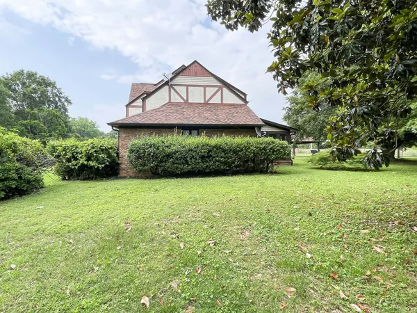 a large kitchen with stainless steel appliances granite countertop a stove a refrigerator a sink dishwasher and wooden cabinets with wooden floor