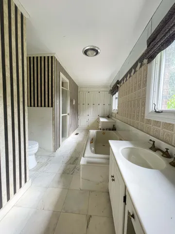 a spacious bathroom with a double vanity sink and a mirror