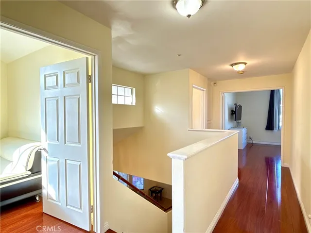 a view of a hallway with furniture and wooden floor