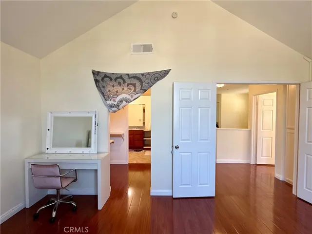 a view of a hallway to room with wooden floor windows and a kitchen