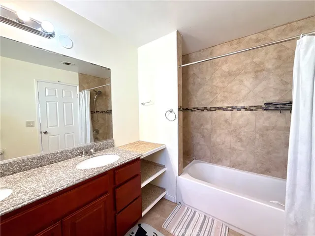 a bathroom with a tub shower and sink