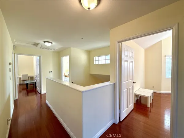 a view of a hallway with bathroom and wooden floor
