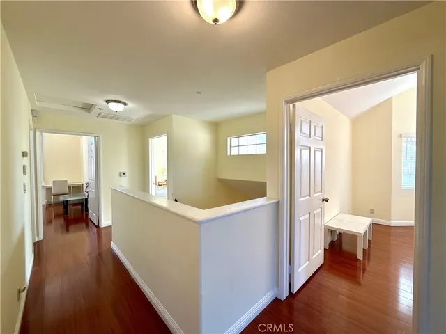 a view of a hallway with bathroom and wooden floor