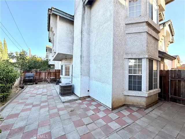 a view of a porch with a bench and potted plants
