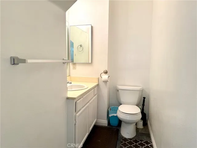 a bathroom with a granite countertop toilet and a sink