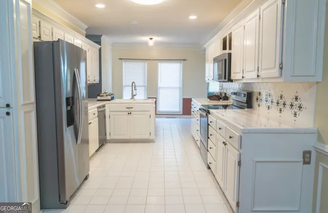 a kitchen with stainless steel appliances a refrigerator sink and cabinets