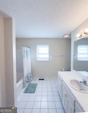 an empty room with windows and chandelier fan