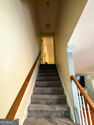 an empty room with wooden floor chandelier fan and windows