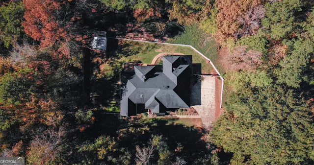 a aerial view of a house with a yard and large trees
