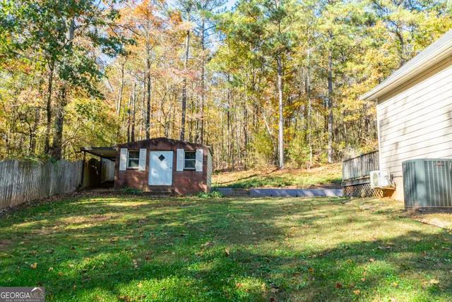 a view of a house with a big yard and large trees