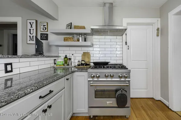 a kitchen with granite countertop a stove sink and cabinets