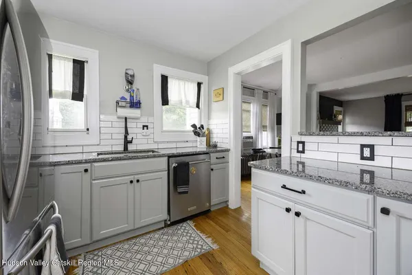 a kitchen with granite countertop cabinets stainless steel appliances a sink and a window