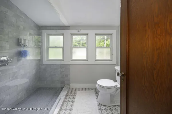 a bathroom with a toilet a window and a shower