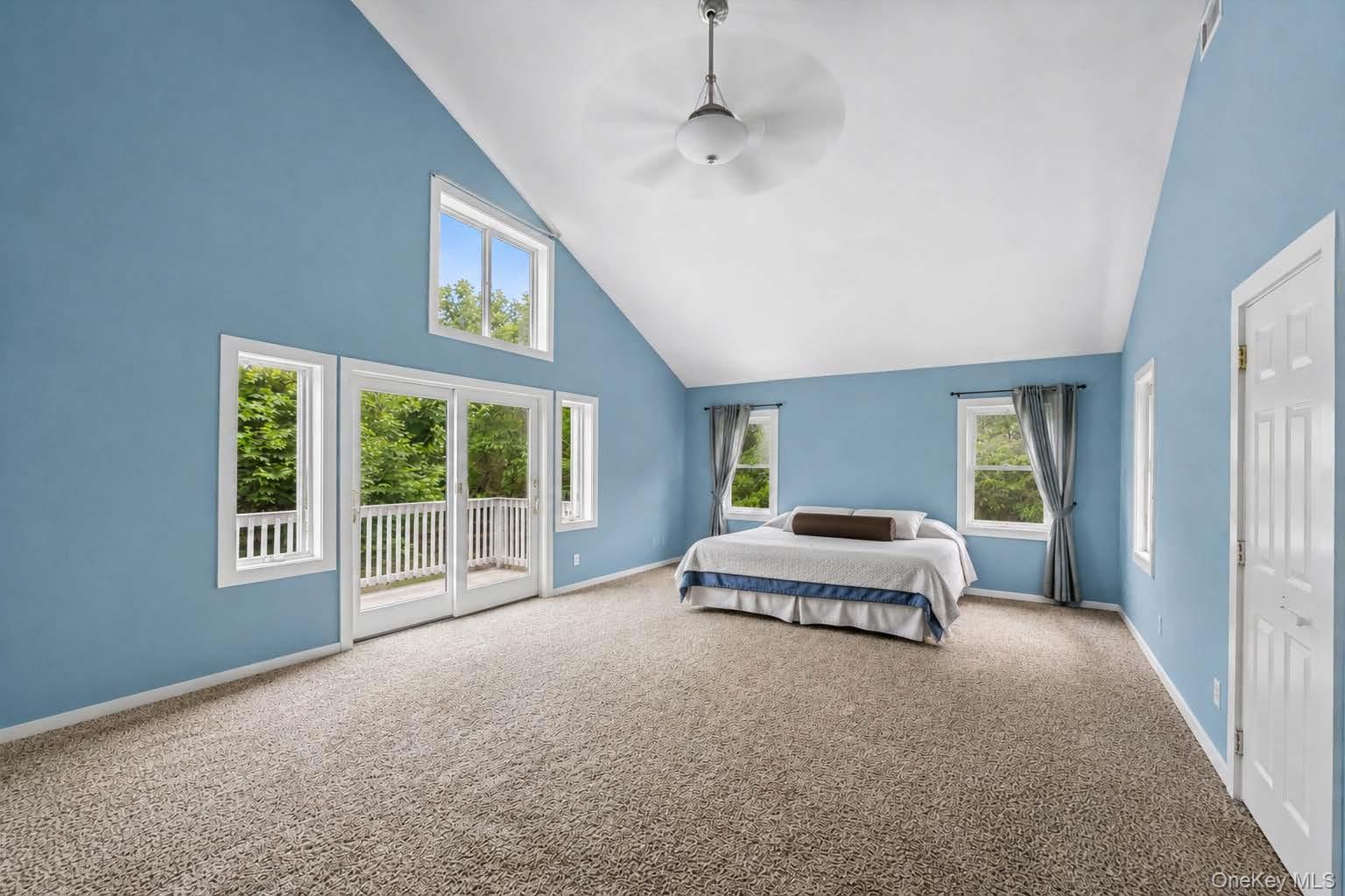 131 Red Creek Road Hampton Bays, NY 11946 - Photo 22 of 35 a spacious bedroom with a bed and a large window