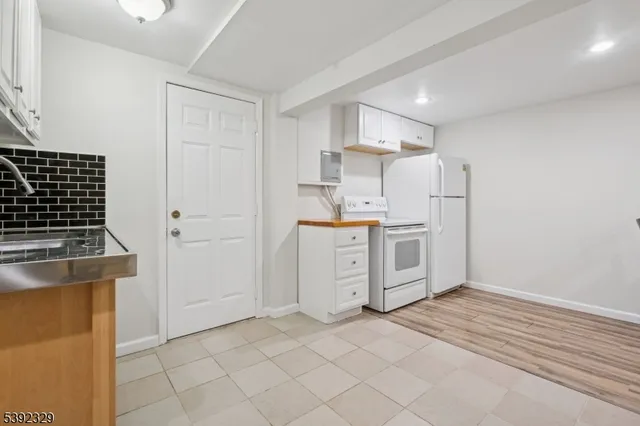 a kitchen with white cabinets and white appliances