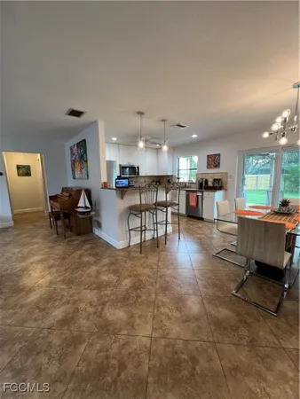 a living room with furniture and a dining table with kitchen view