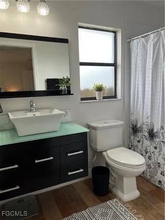 a bathroom with a sink toilet and mirror