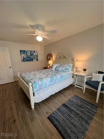 a bedroom with a bed and a dresser with wooden floor