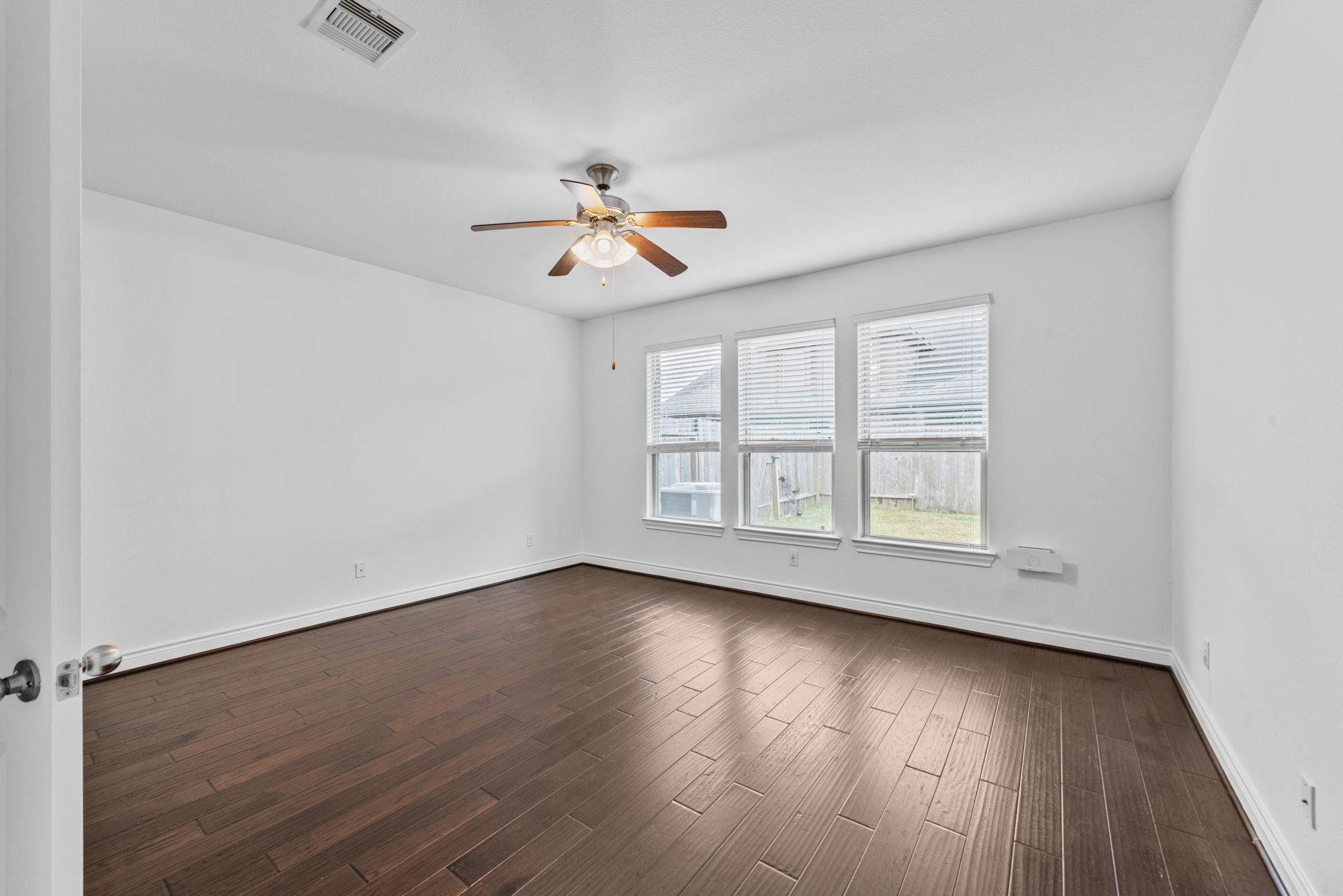 24211 Cordova Brook Lane Katy, TX 77494 - Photo 21 of 42 an empty room with wooden floor chandelier fan and windows