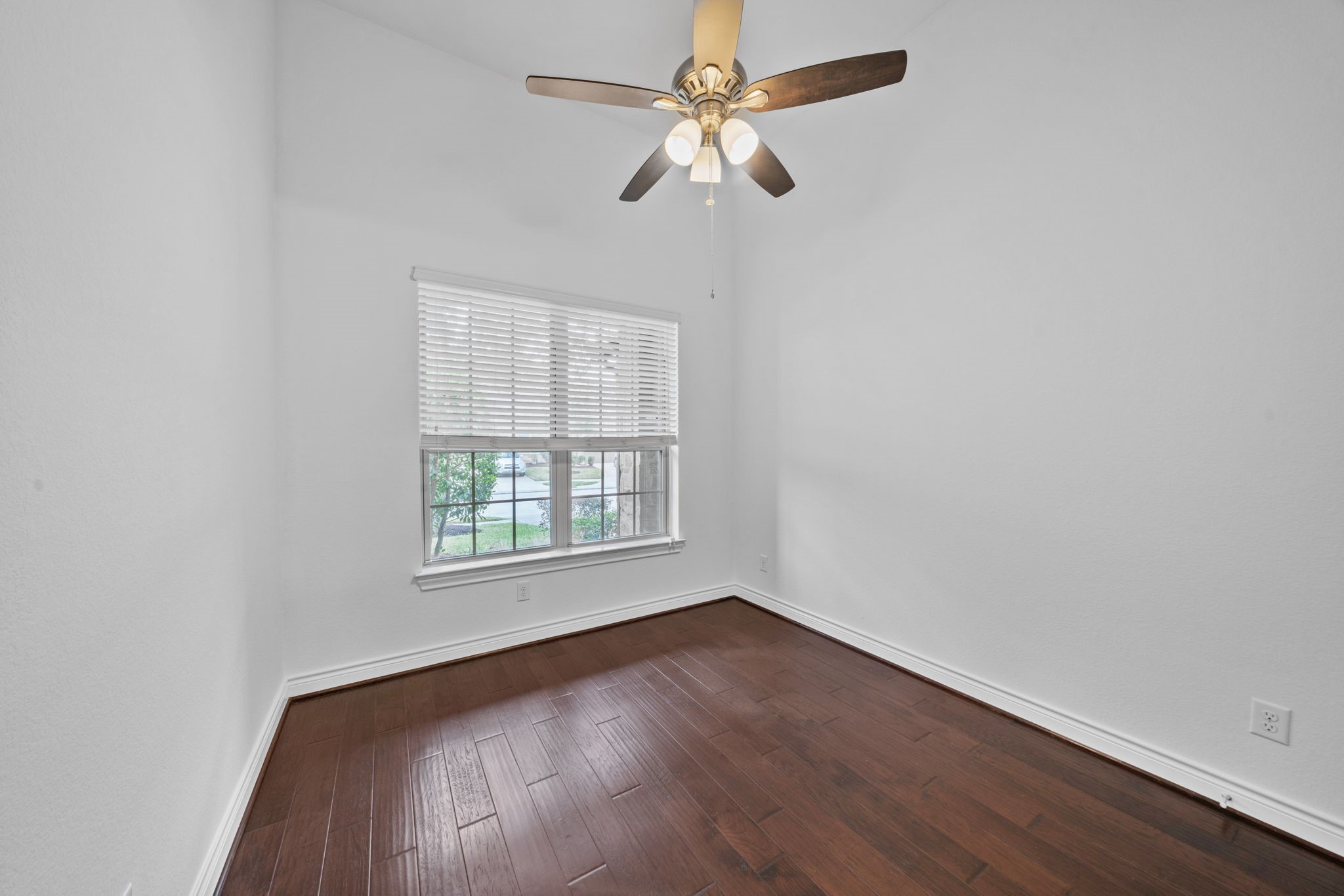 24211 Cordova Brook Lane Katy, TX 77494 - Photo 6 of 42 an empty room with wooden floor fan and windows
