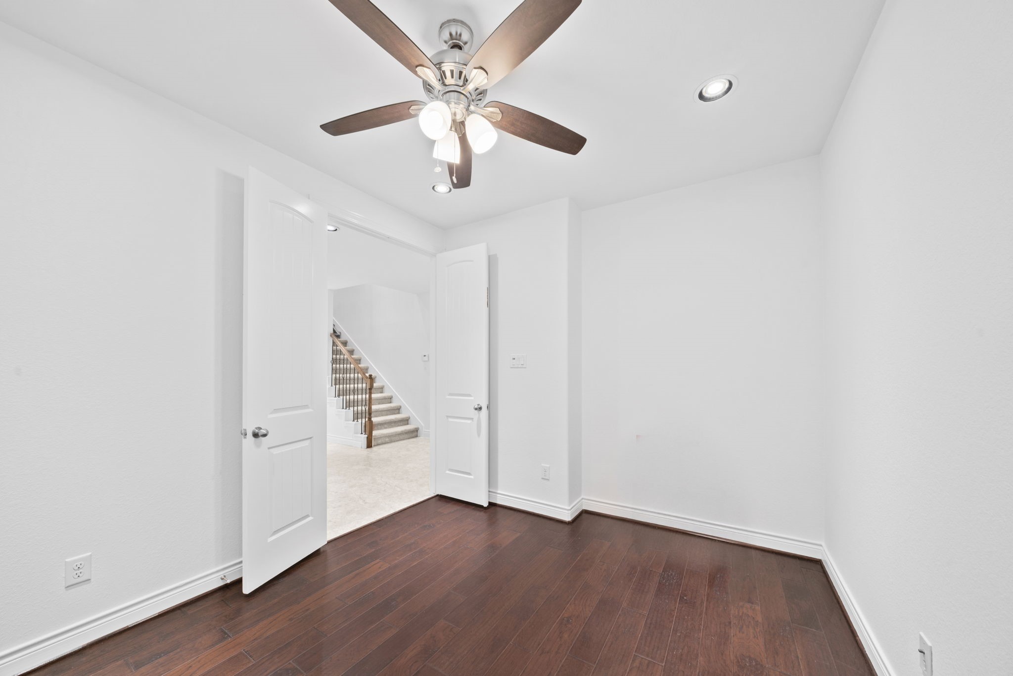 24211 Cordova Brook Lane Katy, TX 77494 - Photo 9 of 42 an empty room with wooden floor ceiling fan and windows