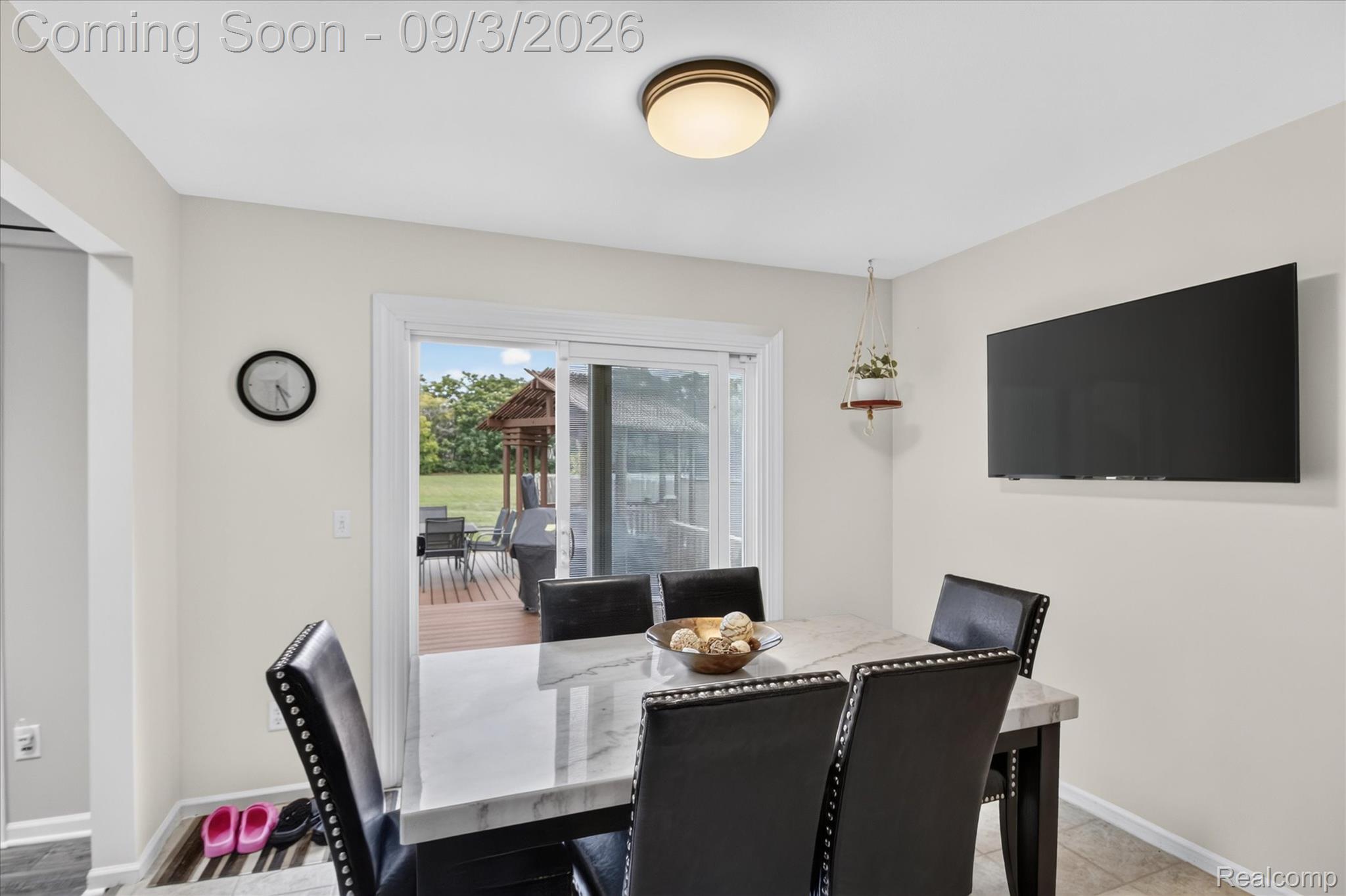 27260 Campbell Road Warren, MI 48093 - Photo 12 of 60 Sliding glass door, flush mount ceiling light, wall-mounted television, and neutral wall paint